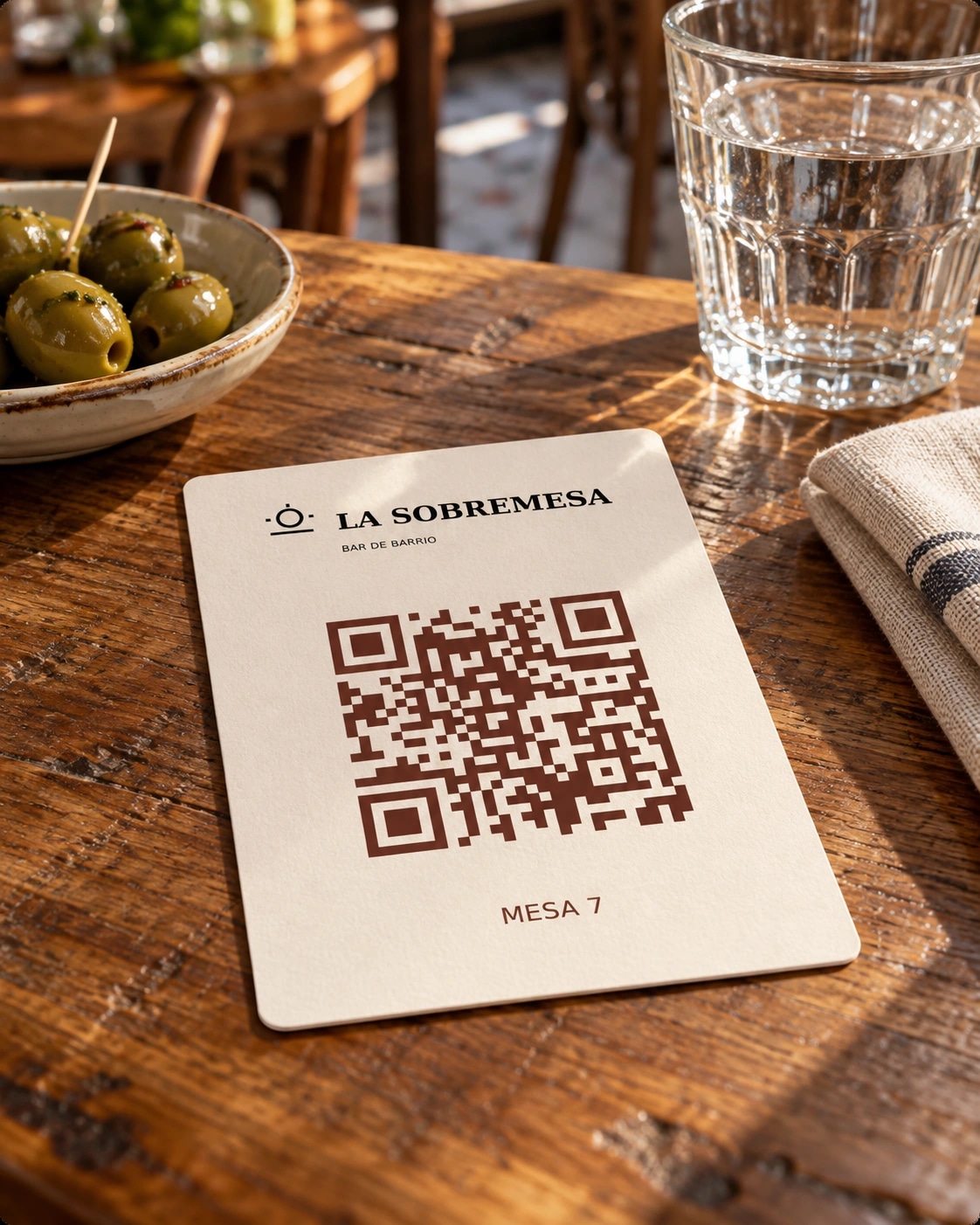 Mesa de bar con un QR y la identidad del restaurante ficticio La Sobremesa